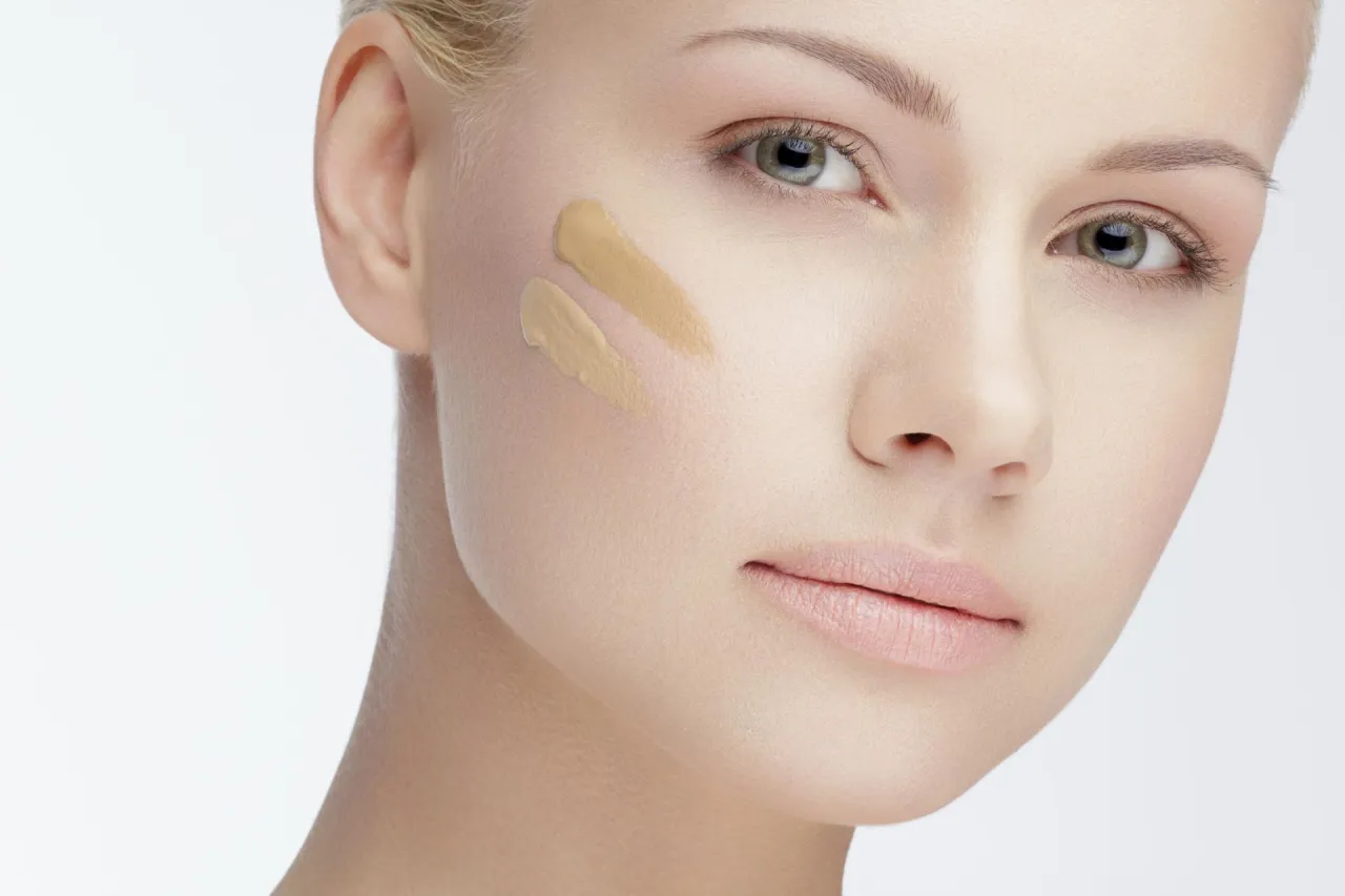 kobieta nakładająca podkład na r&oacute;żne typy cery