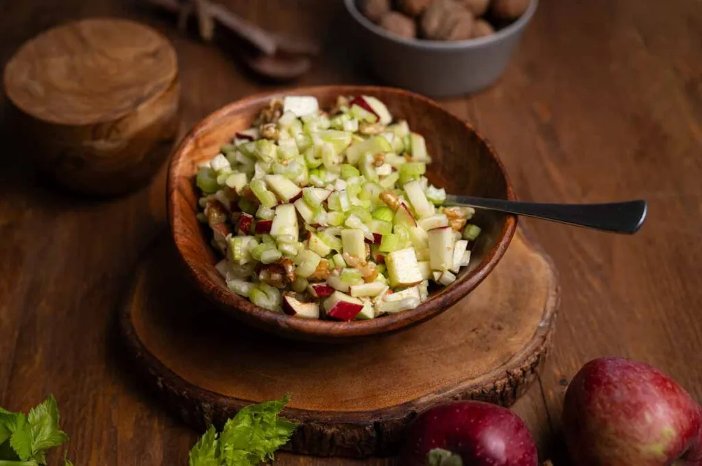 appetitlicher Selleriesalat in einer Sch&uuml;ssel auf einem Holztisch