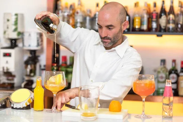 barman w eleganckiej restauracji przygotowuje koktajl