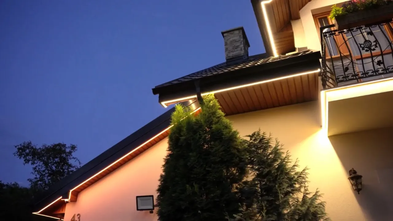 Eleganckie lampy w podbitce podkreślają architekturę domu, tworząc ciepłą atmosferę wieczorem.