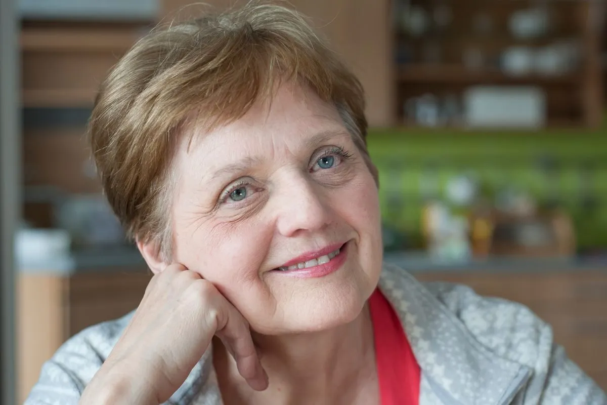 uśmiechnięta kobieta w wieku 60 lat korzystająca z komunikacji miejskiej