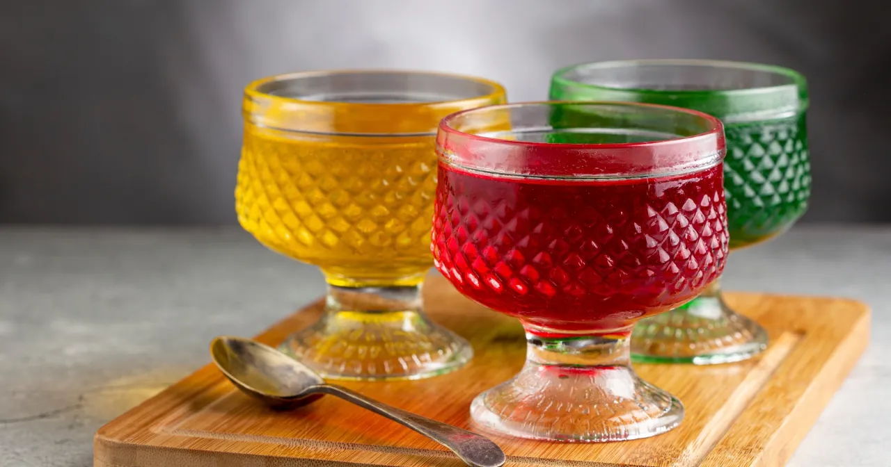 Trzy kolorowe galaretki owocowe w kieliszkach. Czy galaretka owocowa jest zdrowa? Zależy od składników, ale te wyglądają apetycznie.