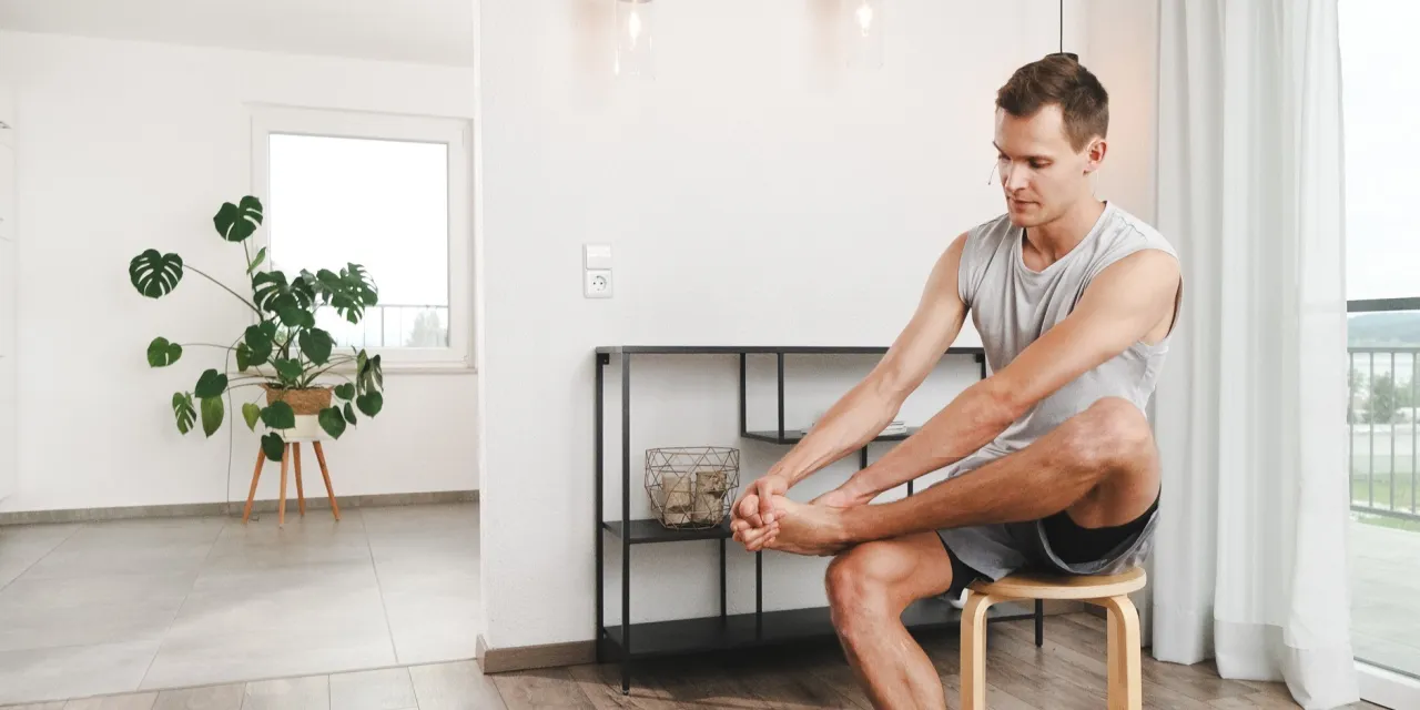 Person macht Fußübungen am Schreibtisch