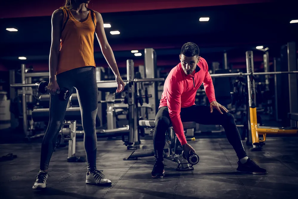 osoba ćwicząca wieczorem w siłowni
