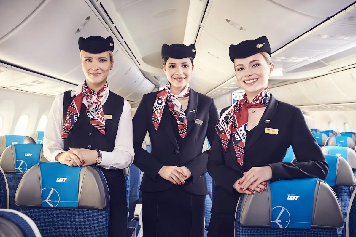 Trzy uśmiechnięte stewardessy LOT-u w eleganckich mundurach. Ciekawe, ile zarabia steward w LOT?