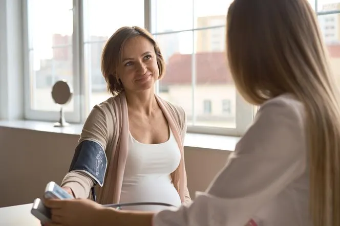 kobieta w ciąży mierząca ciśnienie krwi