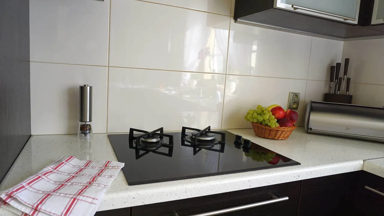 układanie płytek między szafkami w kuchni