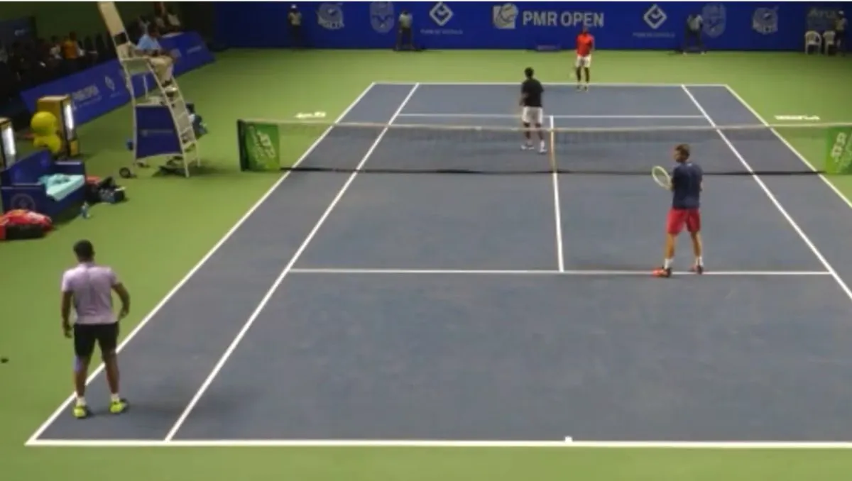 Tenisista serwujący i odbierający na korcie