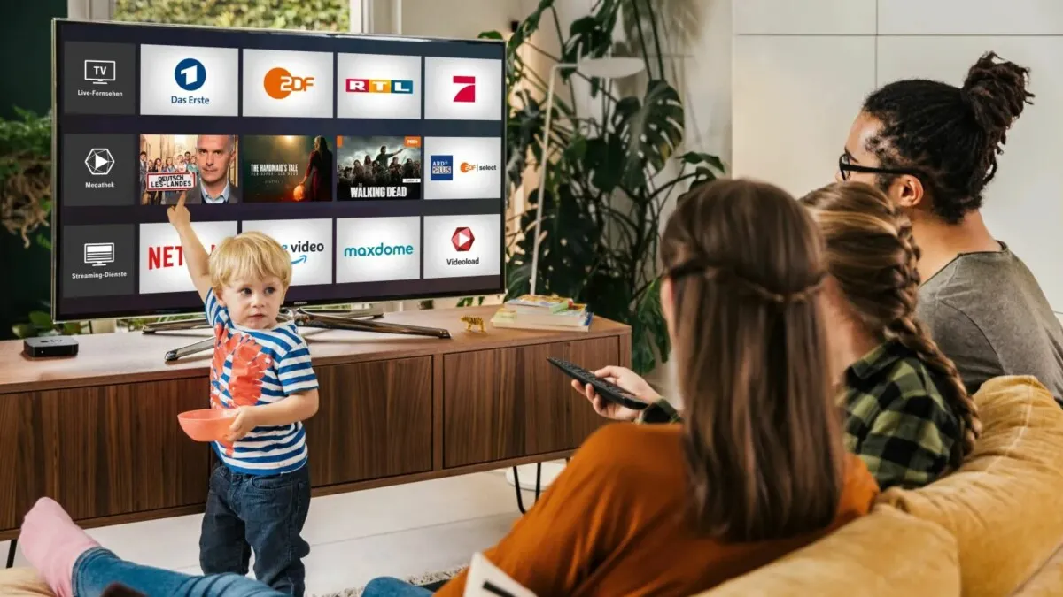 Frau schaut Live-Fernsehen auf Tablet und Smart-TV gleichzeitig