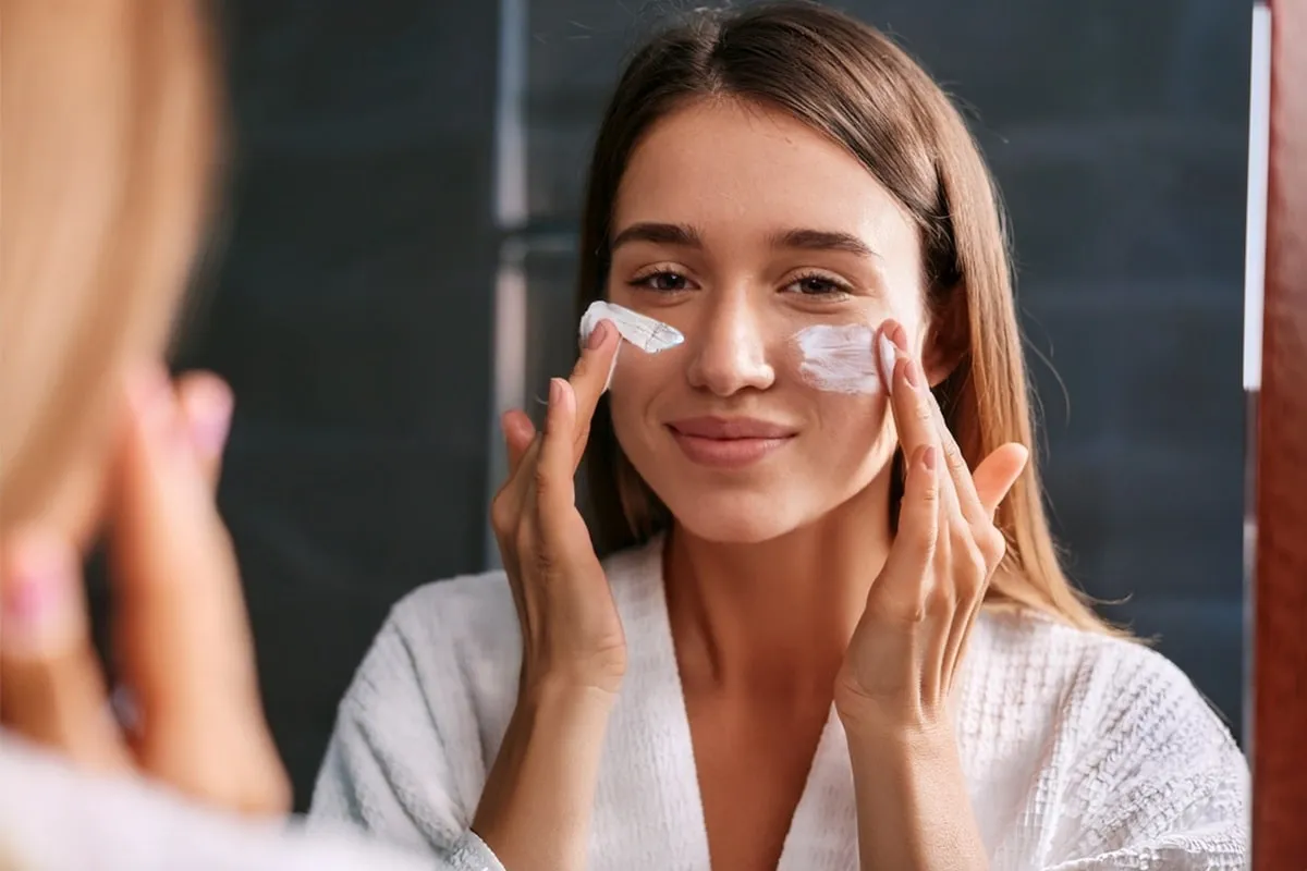 Kobieta chroniąca twarz przed słońcem po zabiegu medycyny estetycznej