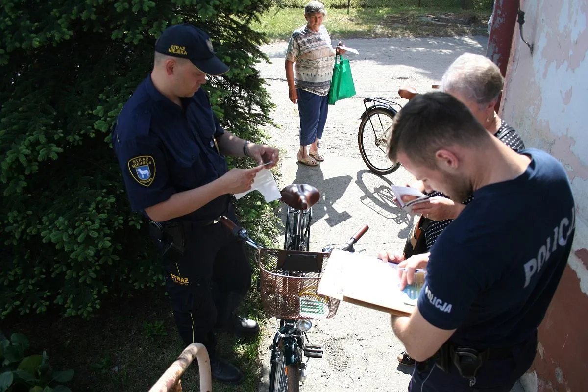 Strażnicy miejscy sprawdzają dokumenty i jak oznakować rower, by zapobiec kradzieży.