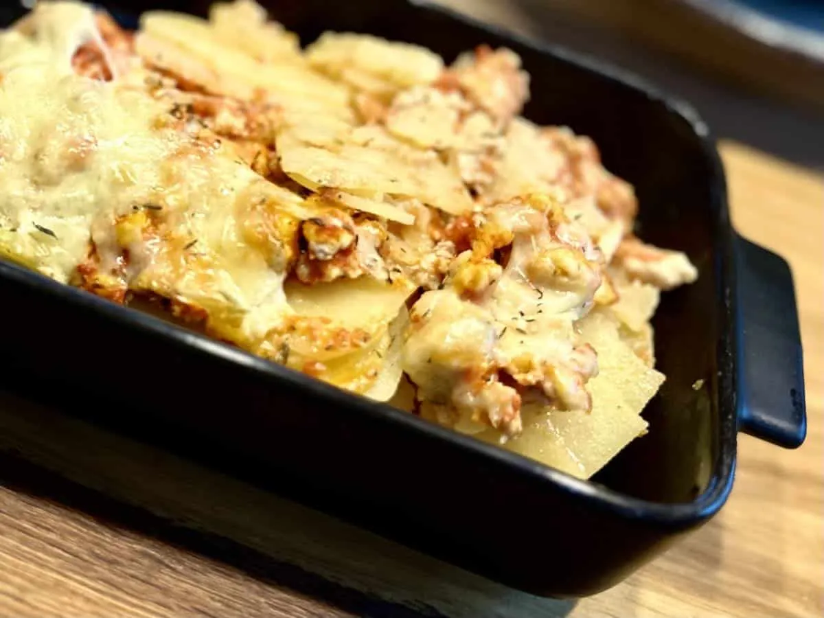 Zapiekanka ziemniaczana w naczyniu żaroodpornym przed pieczeniem