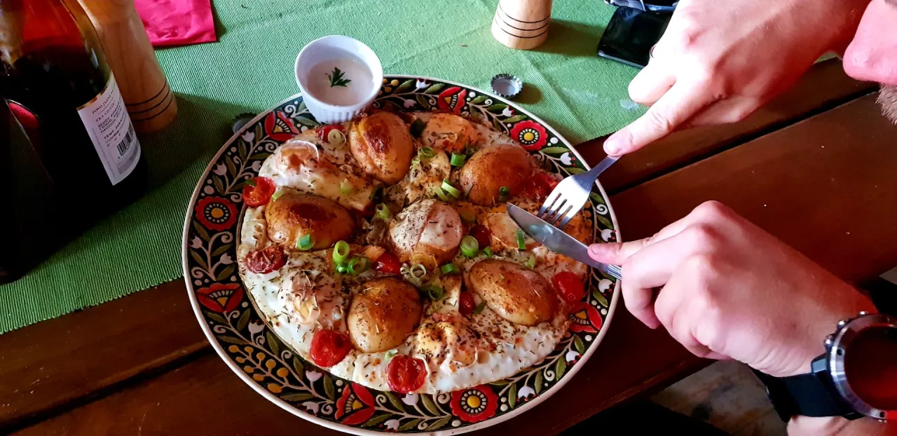 Pyszne jajka sadzone z ziemniakami i pomidorkami na ludowym talerzu. Wspaniała gościna na wierchu!