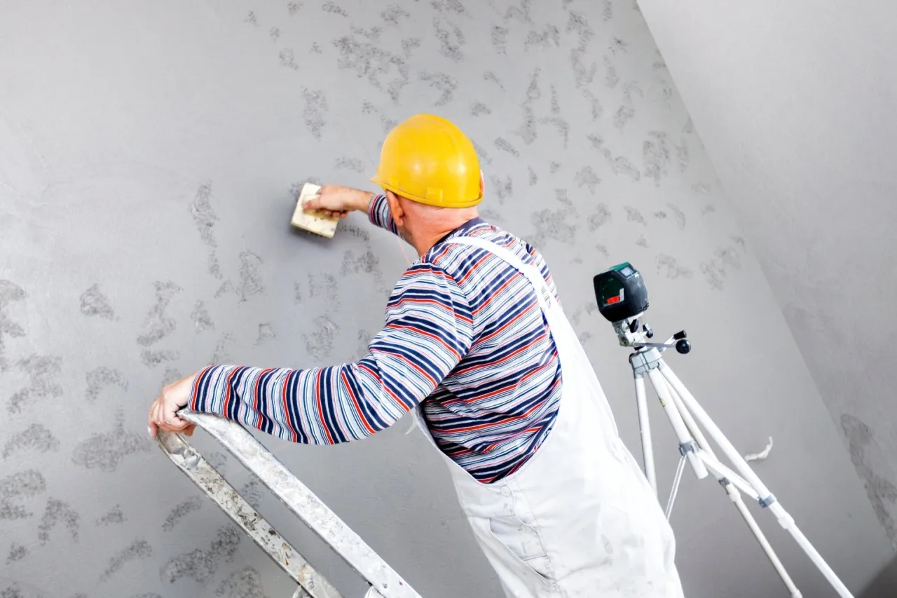 Kobieta oglądająca pr&oacute;bki tynk&oacute;w dekoracyjnych, doradca budowlany