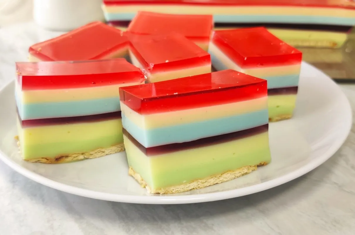 Kolorowy galaretkowiec z serkami homogenizowanymi, ułożony warstwowo na kruchym spodzie.