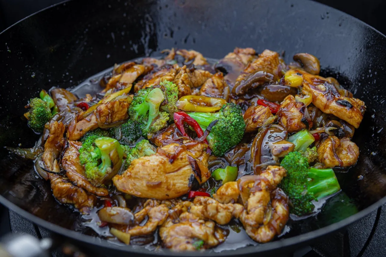 Pyszne dania z woka: kurczak z brokułami, papryką i grzybami w sosie.