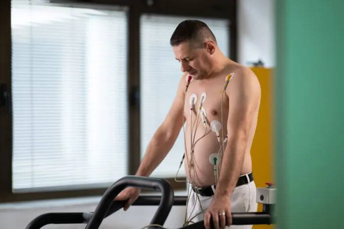 Pacjent ćwiczący na bieżni w ośrodku rehabilitacji kardiologicznej pod nadzorem personelu medycznego