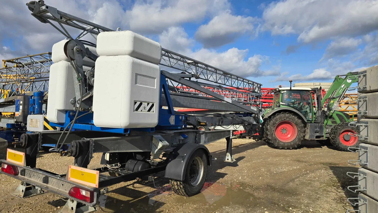 Ciężki sprzęt budowlany, w tym dźwig, czeka na transport. Zastanawiasz się, ile kosztuje dźwig budowlany?