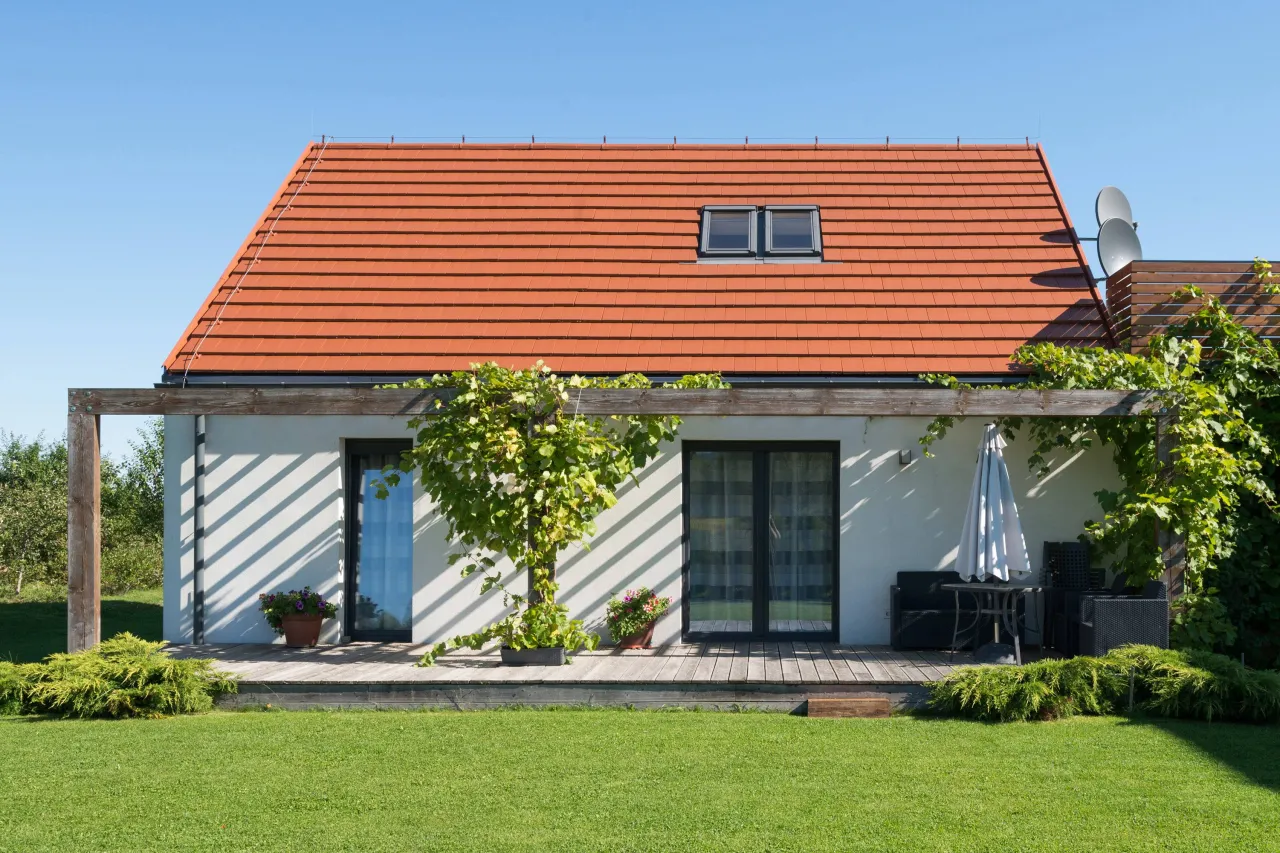 nowoczesne domy z czerwonym dachem i szarą, zieloną, niebieską elewacją