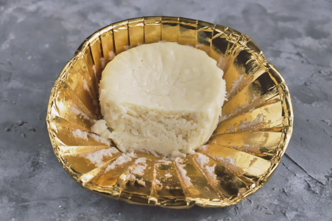 Gotowy do mielenia ser na sernik, w złotej, ozdobnej miseczce.
