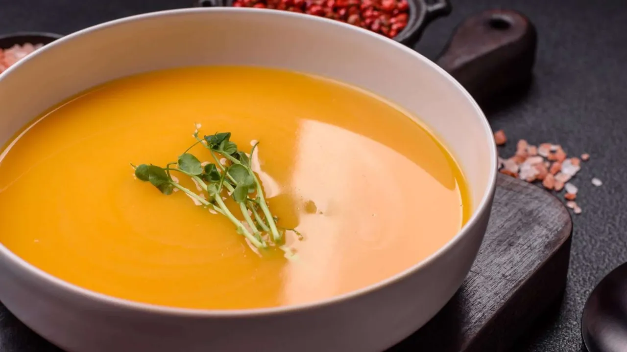 cremige Karotten Ingwer Suppe in einer Schale mit Toppings angerichtet