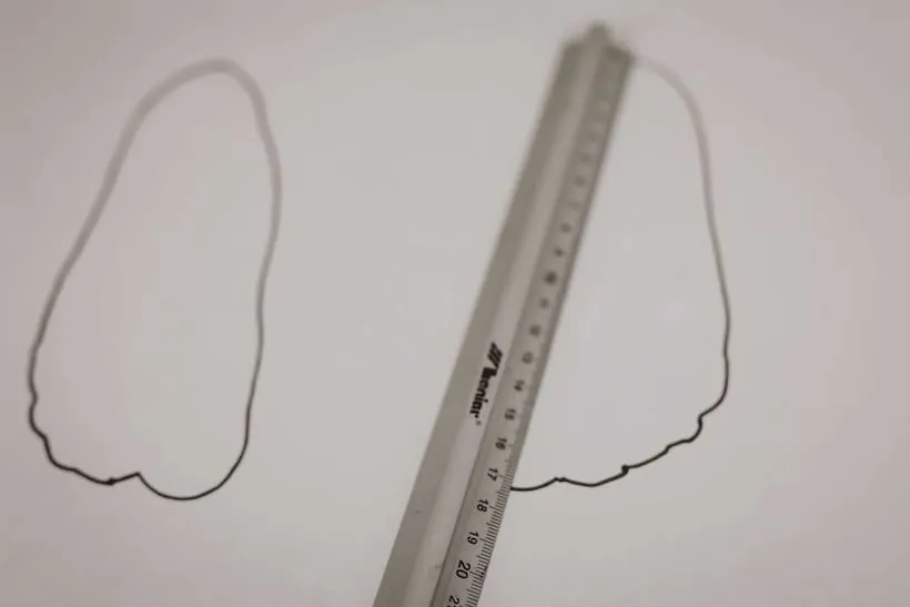 dziecko mierzące stopę na kartce, rodzic mierzy stopę dziecka