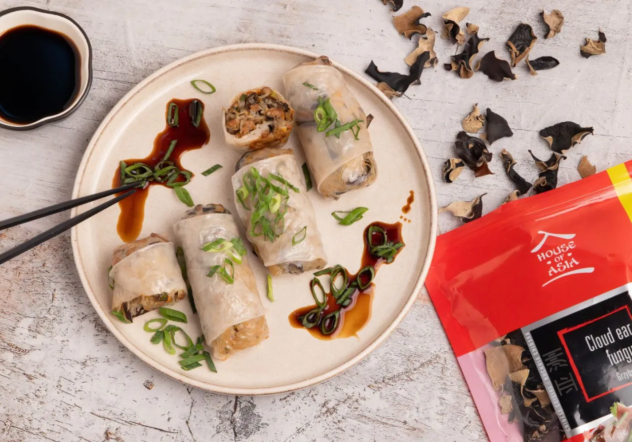 Sajgonki co to? Delikatne rolki z ryżowego papieru z nadzieniem, polane sosem sojowym i posypane szczypiorkiem. Obok suszone grzyby mun.