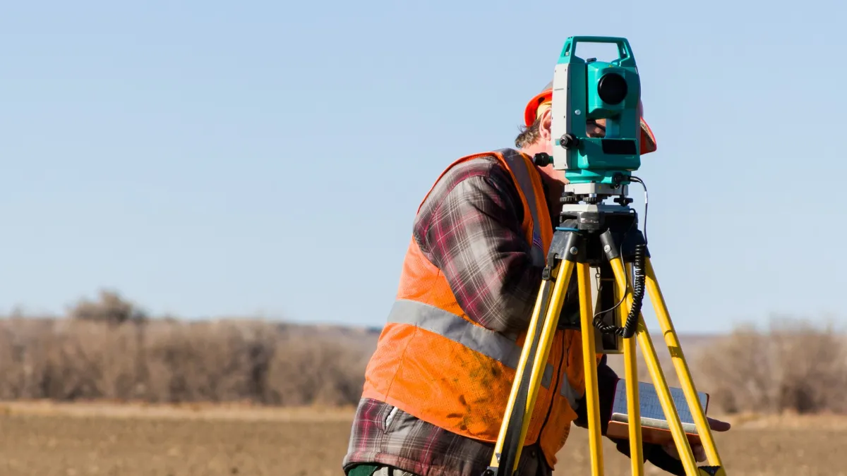 Geodeta w terenie wykonujący pomiary