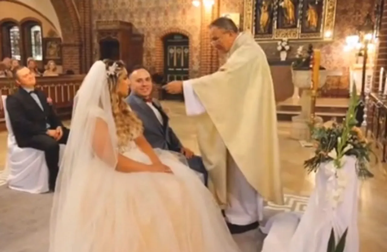 Para młoda rozmawiająca z księdzem w kościele o przygotowaniach do ślubu