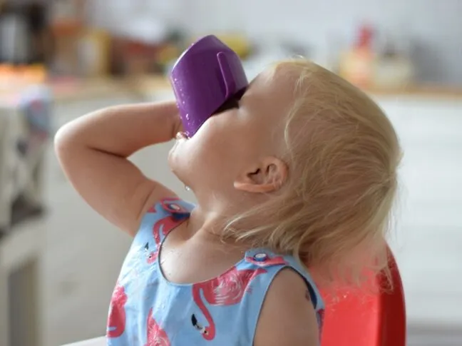 Dziecko pije wodę z kubeczka