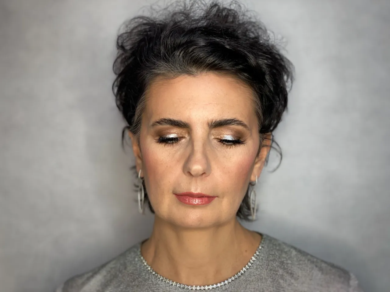 Elegancki makijaż po 60-tce: błyszczące powieki, delikatny r&oacute;ż na policzkach i połyskujące usta.