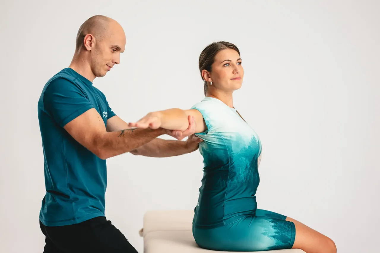 Fizjoterapeuta pomaga pacjentce w ćwiczeniach ramienia. Długość rehabilitacji po złamaniu ręki zależy od wielu czynników.