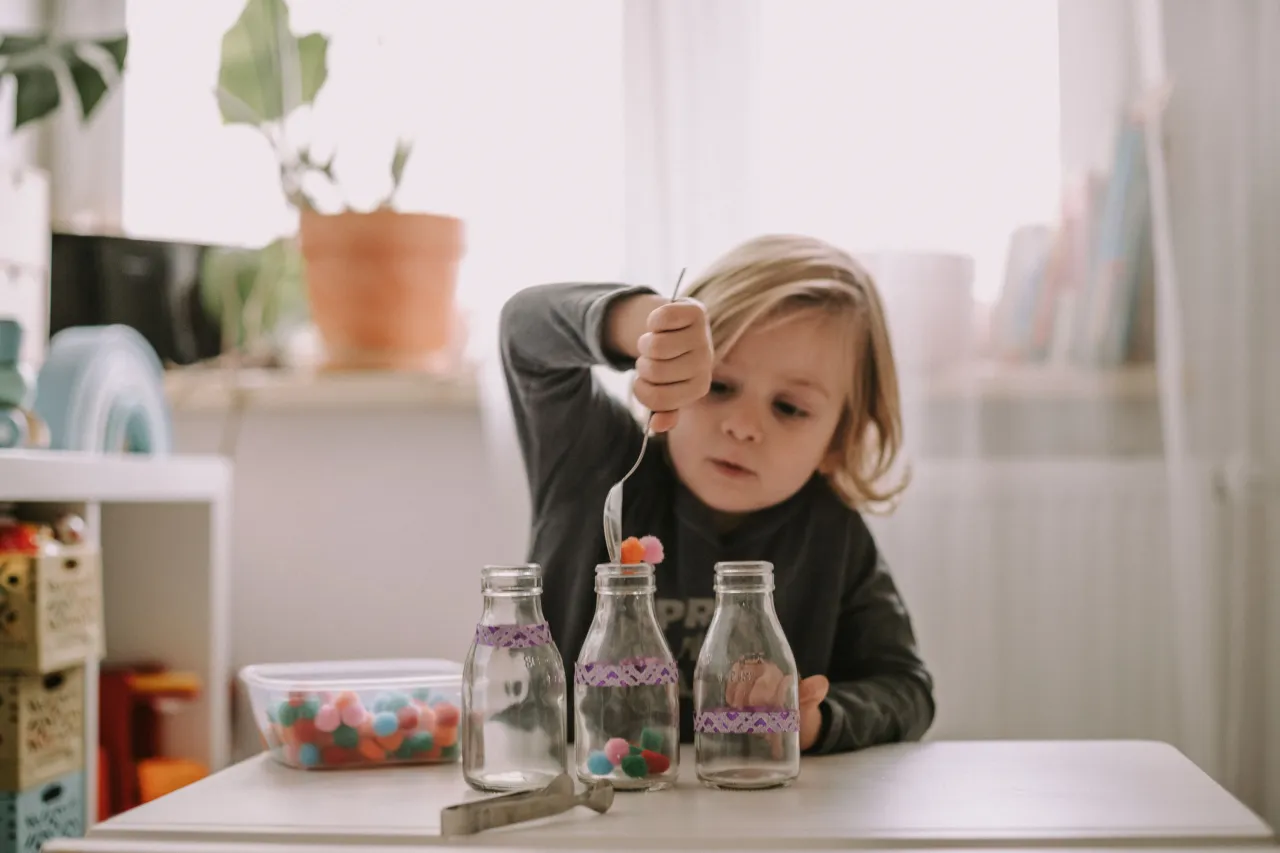 Rodzic i dziecko bawiące się wsp&oacute;lnie w domu, uśmiechnięte