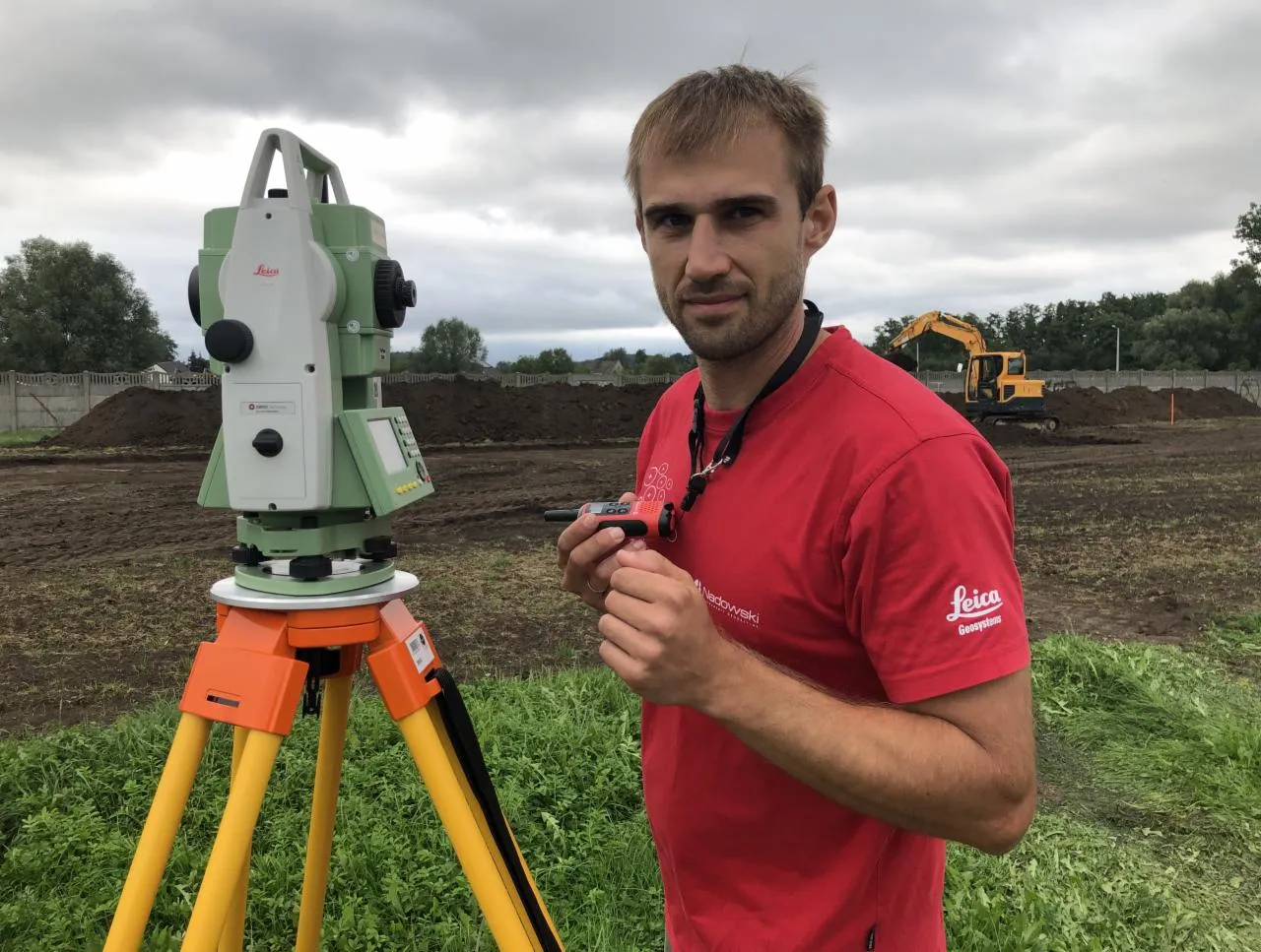 geodeta z niwelatorem w terenie