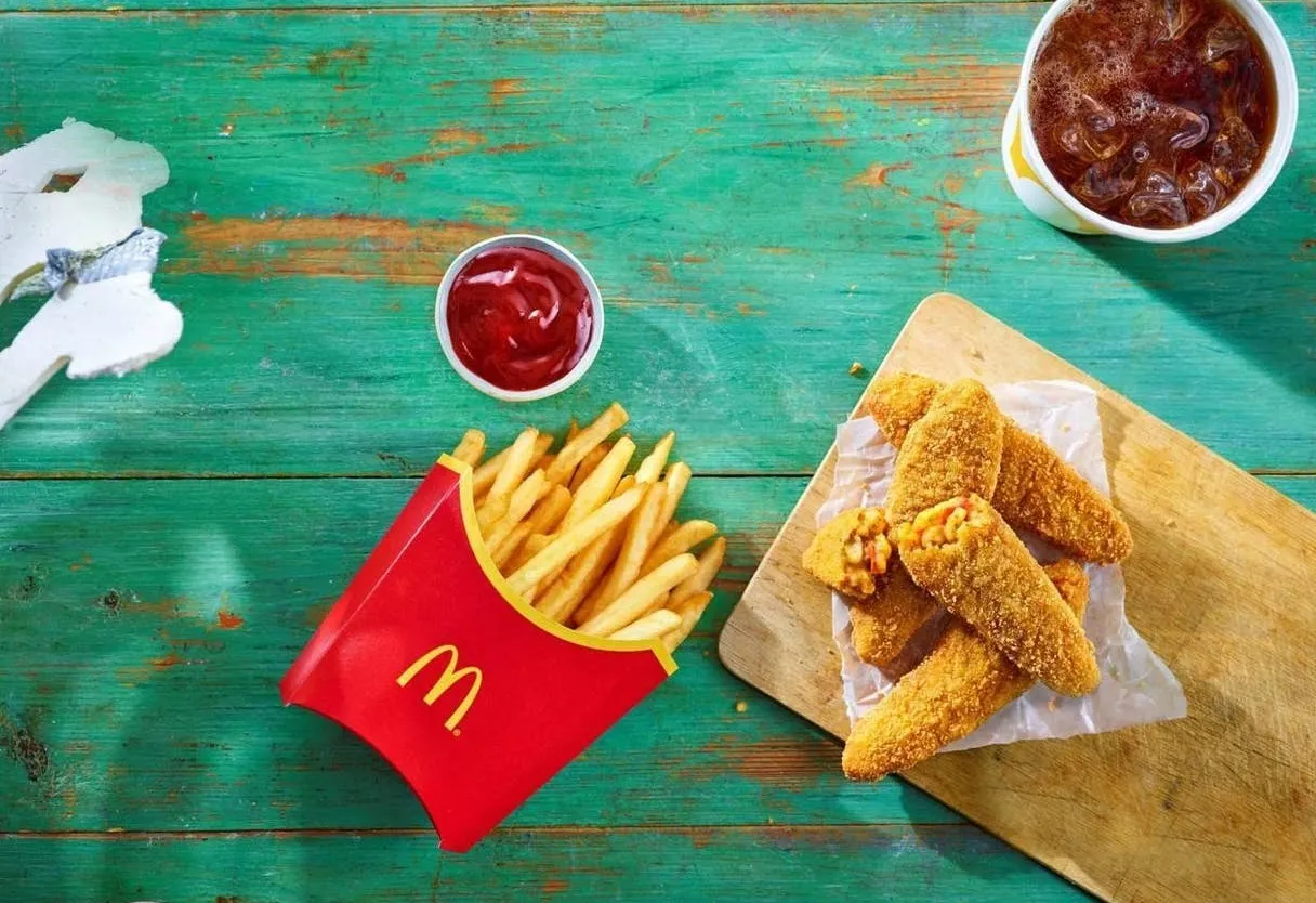 Co jest wege w maku? Chrupiące nuggetsy z fasoli i frytki na zielonym tle.