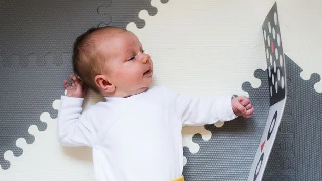 dziecko oglądające kontrastową książeczkę