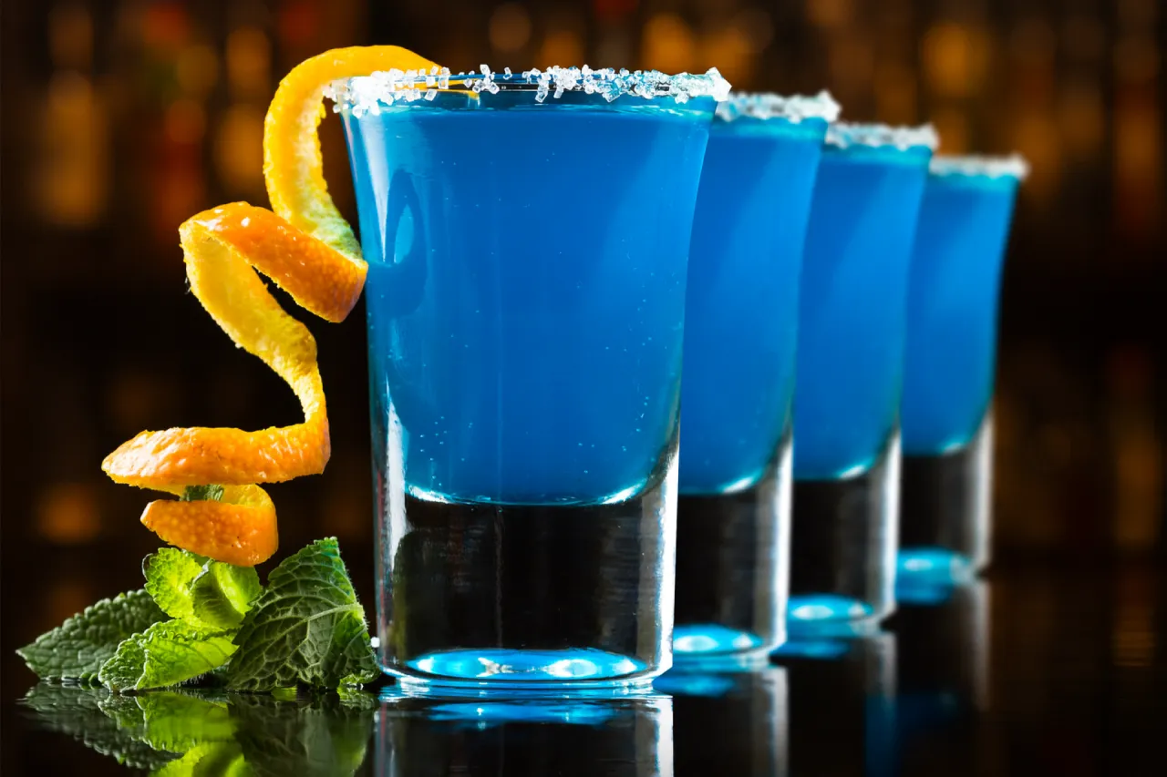 Błękitne shoty Kamikaze, z pomarańczową skórką i miętą, idealne jako alternatywa dla blue curacao.