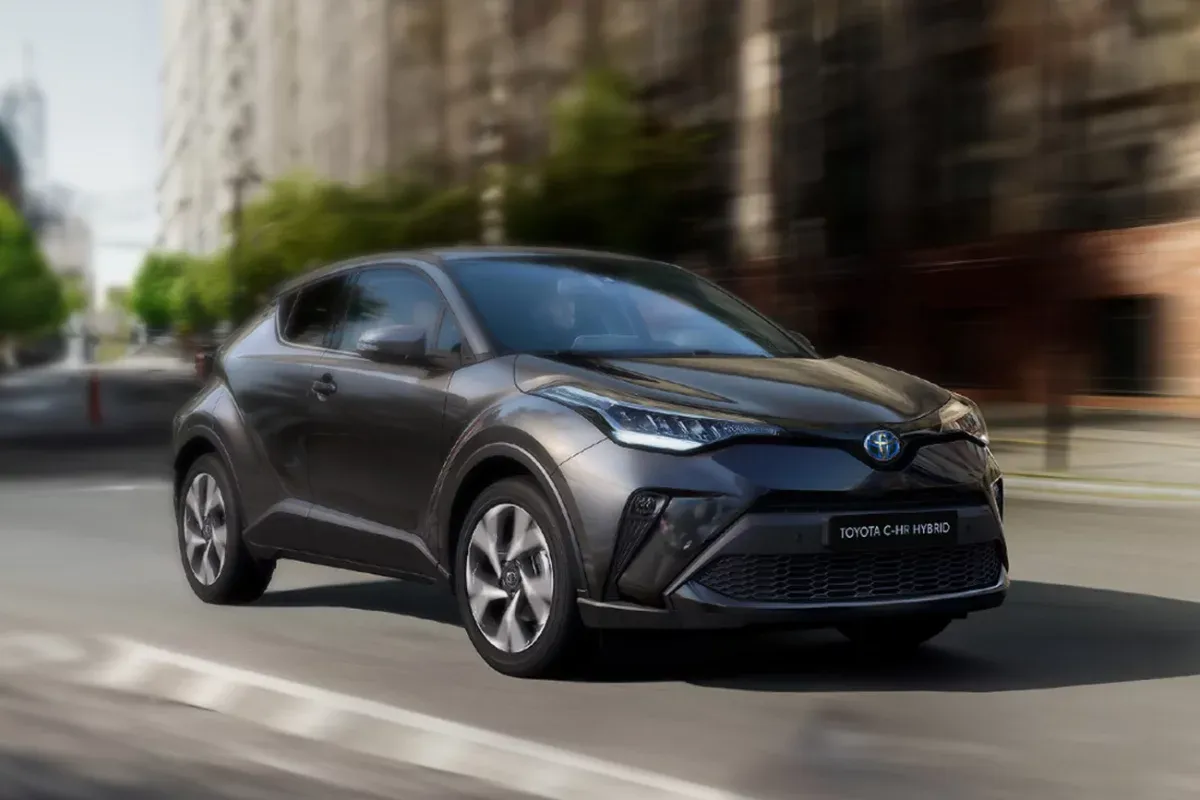 Szary Toyota C-HR Hybrid pędzi ulicą. Zastanawiasz się, ile pali Toyota C-HR Hybrid? Ten stylowy crossover zachwyca niskim spalaniem.