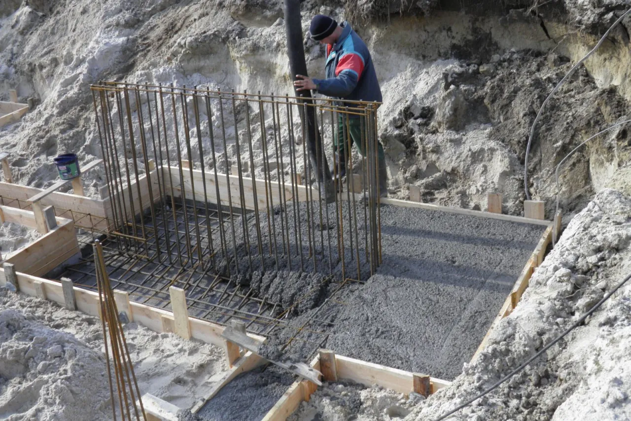Budowlaniec wylewa beton do szalunku zbrojonego. Betonowanie można przeprowadzać do ok. 5&deg;C, poniżej tej temperatury wymagane są specjalne środki.