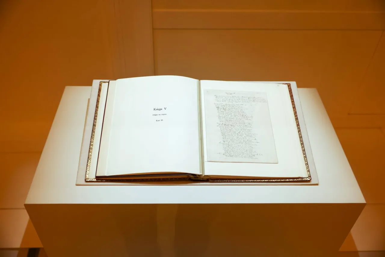 Otwarta księga z rękopisem, przypominająca o tym, kiedy powstał Pan Tadeusz.