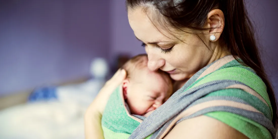 rodzic noszący dziecko w chuście, spokojne niemowlę, rodzic odpoczywający