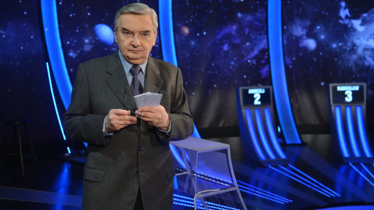 Stars and planets w tle, prowadzący trzyma karty z napisem 