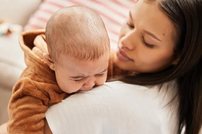 zdezorientowane niemowlę w ramionach mamy