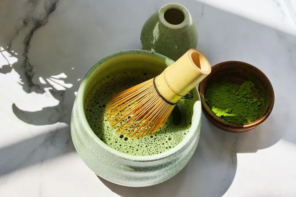 Matcha w filiżance z bambusową miotełką