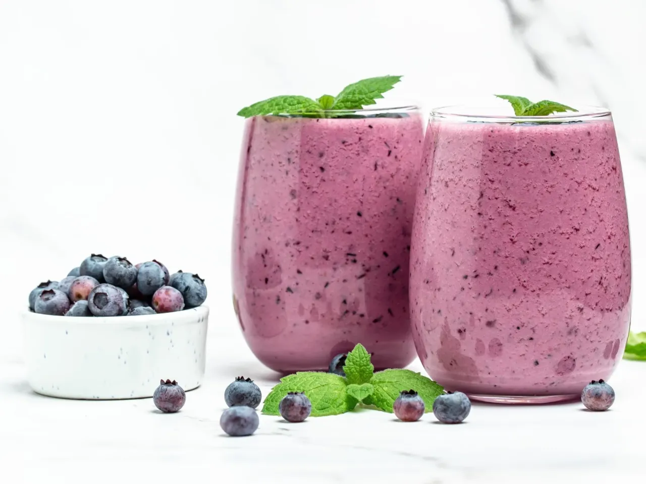 Dwa pyszne koktajle jagodowe z miętą. Idealne na zdrową przekąskę, niezależnie od tego, do kt&oacute;rej godziny można jeść owoce.