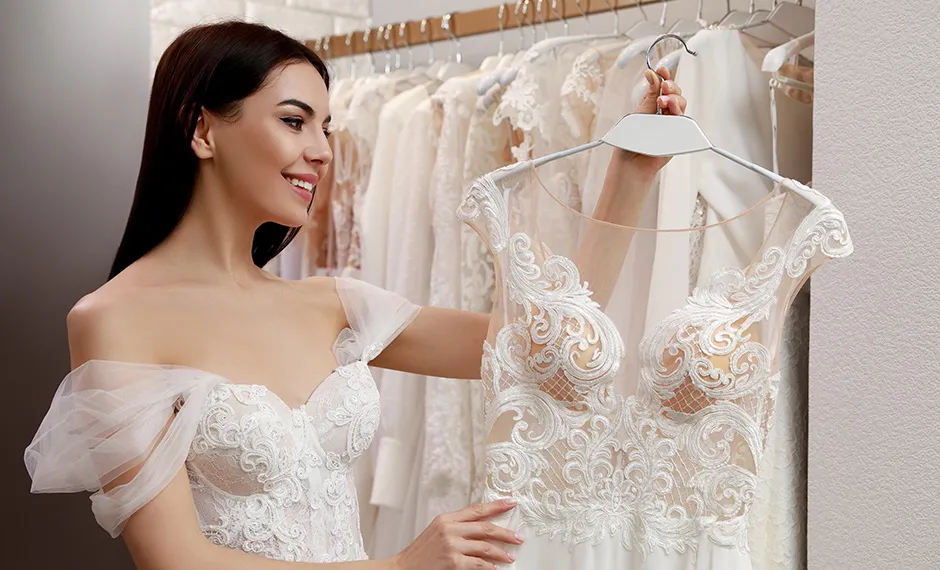 panna młoda przeglądająca suknie ślubne w salonie