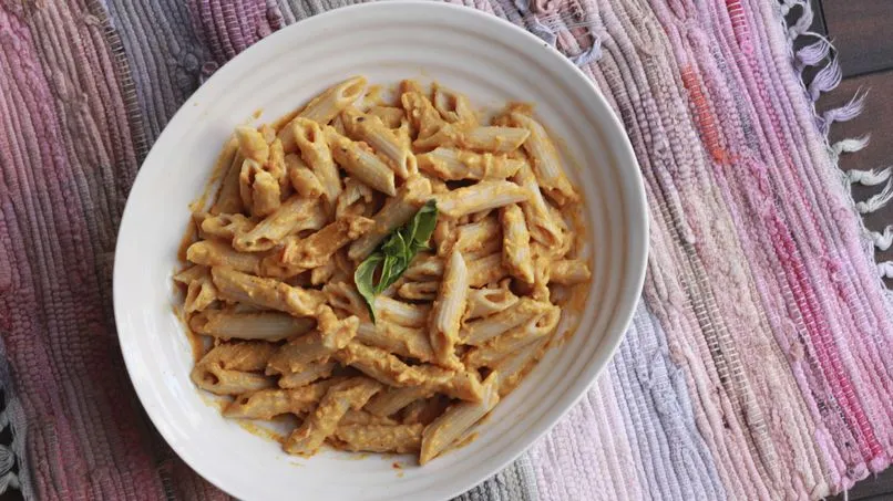 Calabaza butternut y diferentes tipos de pasta corta en una tabla de madera r&uacute;stica