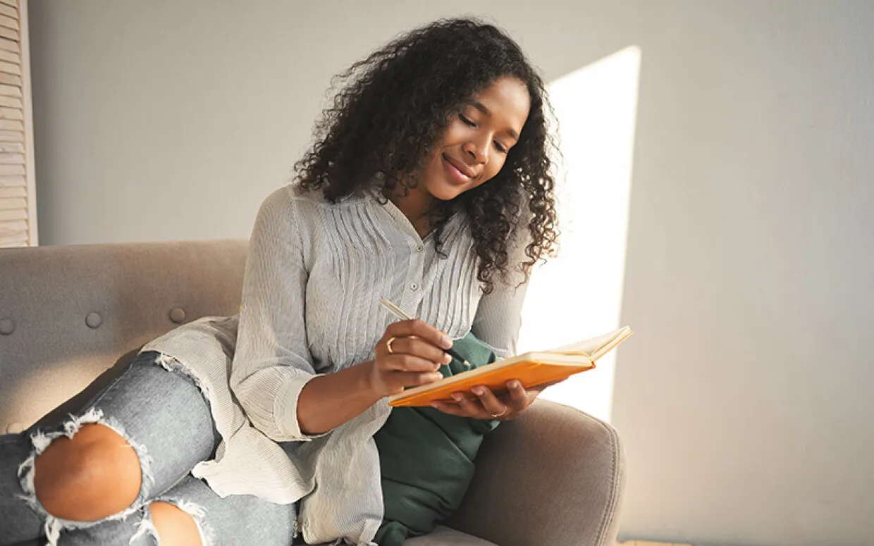 osoba pisząca w dzienniku wdzięczności