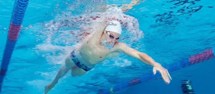 Osoba oswajająca się z wodą w basenie, zanurzanie twarzy, wydychanie powietrza do wody