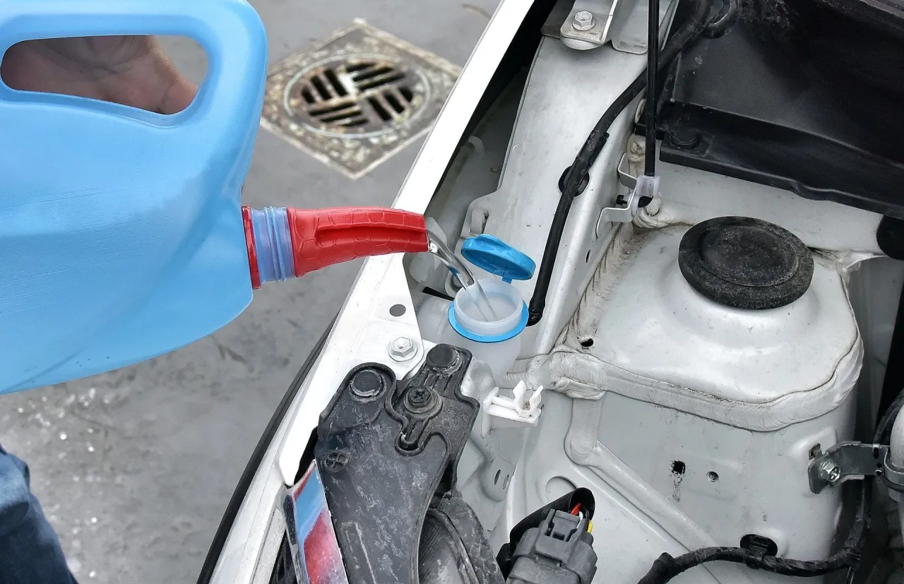 Napełnianie zbiornika płynu do spryskiwaczy, by uniknąć mandatu za brak płynu do spryskiwaczy.